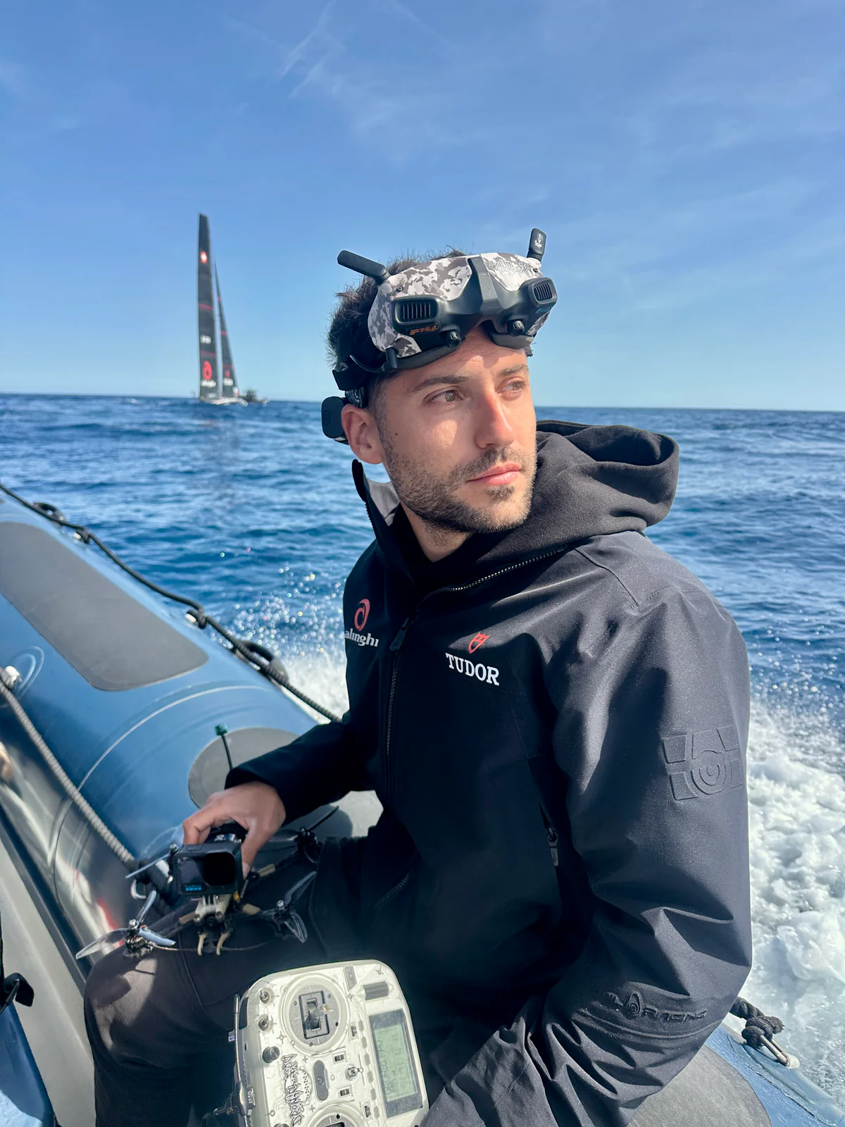 Eric Bofill con gafas FPV en una lancha, con un velero al fondo